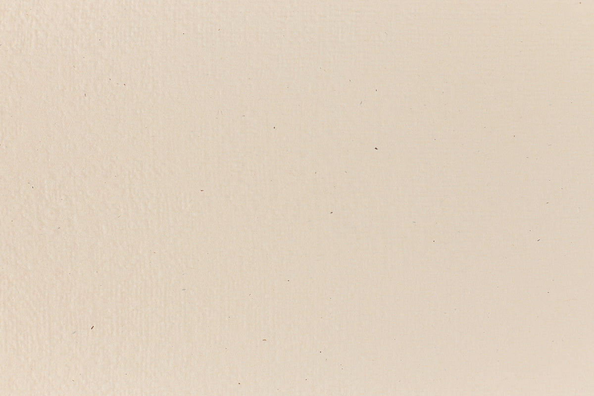 Eggshell-colored and subtly textured construction-style cardstock paper viewed in close detail.