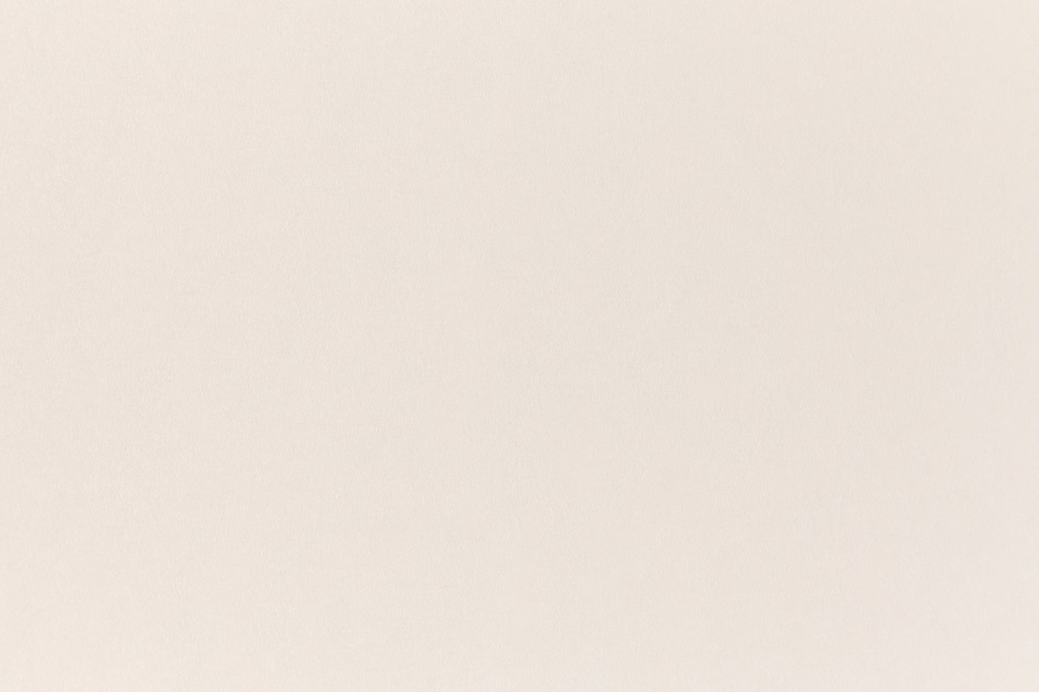 A soft, light pink construction-style cardstock paper viewed closeup.