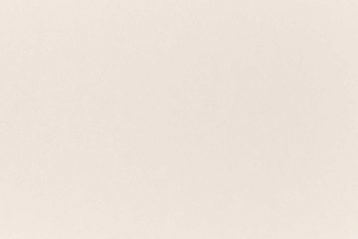 A soft, light pink construction-style cardstock paper viewed closeup.
