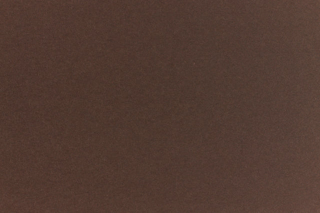 A deep and dark brown-black paper viewed in close detail. 