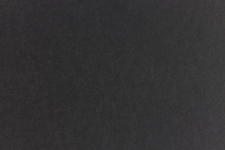 Subtly textured black paper viewed close up. 