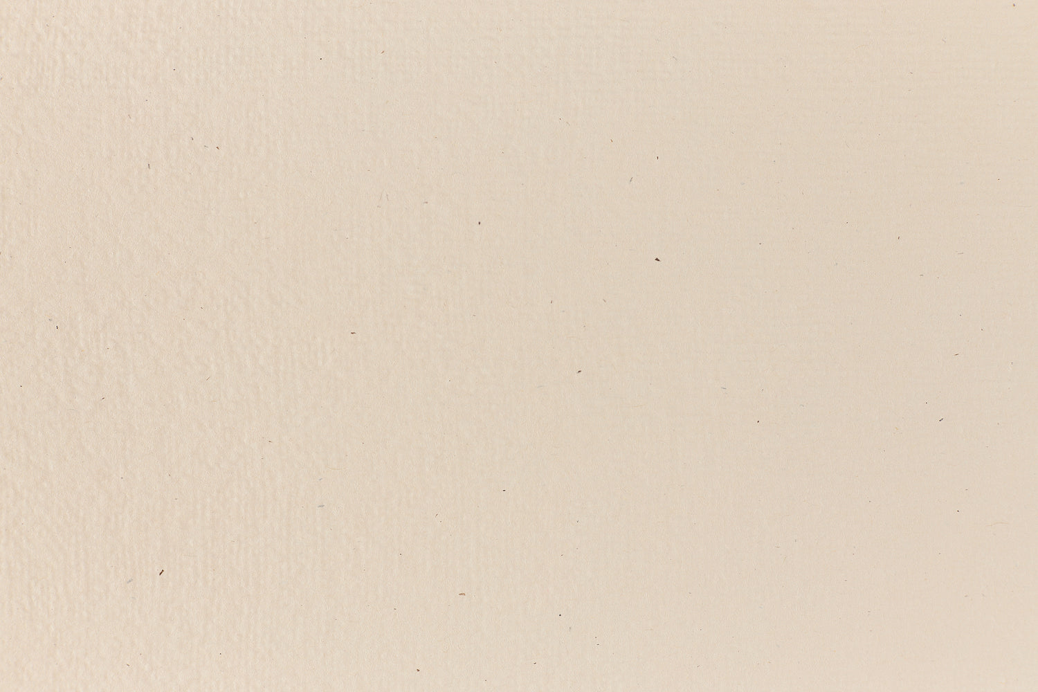 Eggshell-colored and subtly textured construction-style cardstock paper viewed in close detail. 